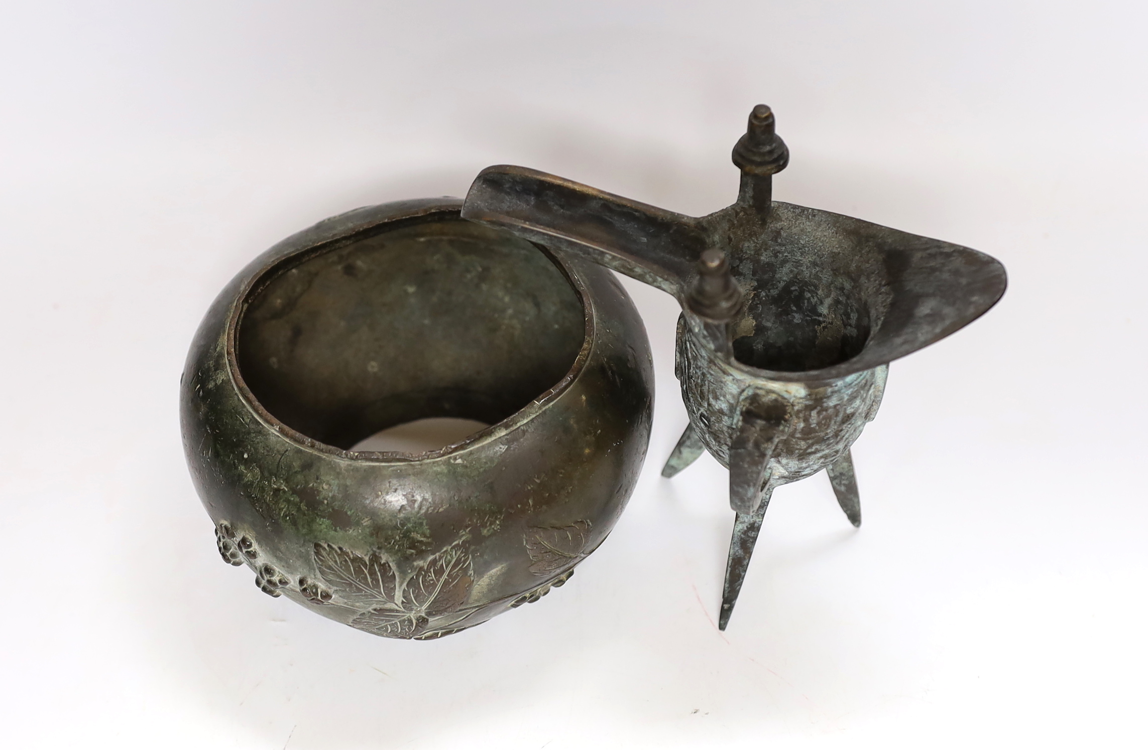 Three Chinese bronze items including a mirror back and a three footed cup, largest 18cm high